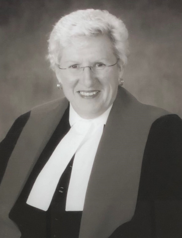 Black and white photo of a female judge wearing glasses.