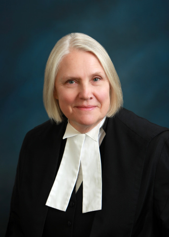 White woman with short white hair, wearing black and white judicial robes.