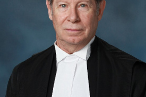 White man in black and white judicial robes.